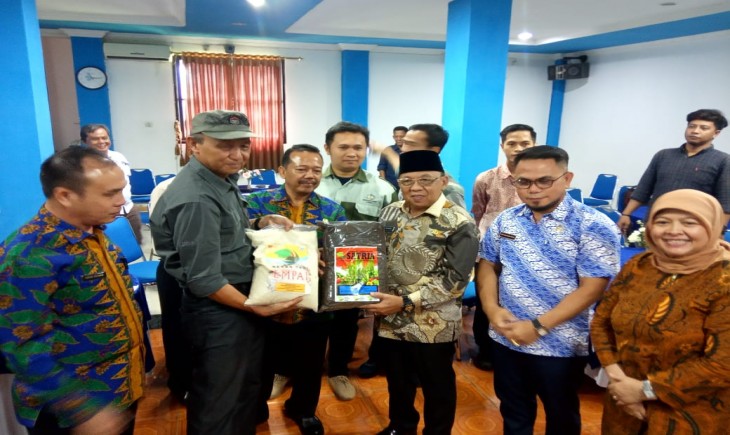Ketua Koptan Tani Maju A, Hartani menyerahkan produk lokal berupa pupuk organik dan padi empai kepada Wabup Lahat, Haryanto didampingi Kepala OPD (Foto : Palpres)